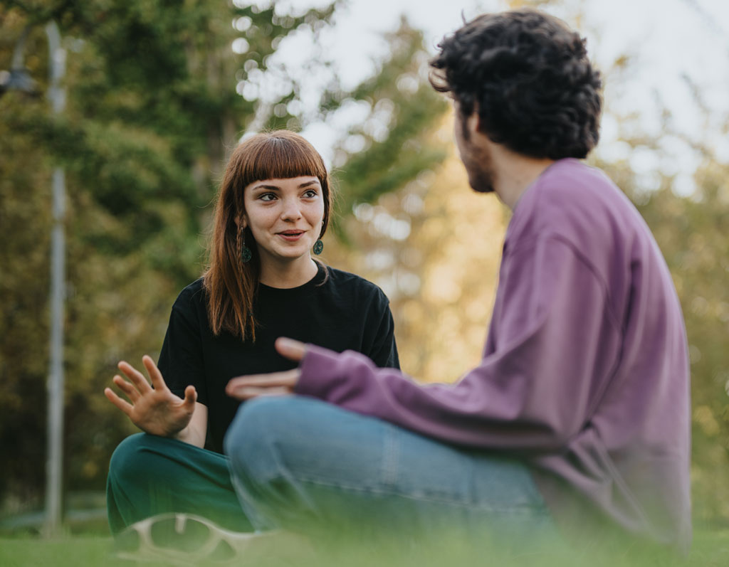 Zwei Freunde sitzen im Park und reden miteinander